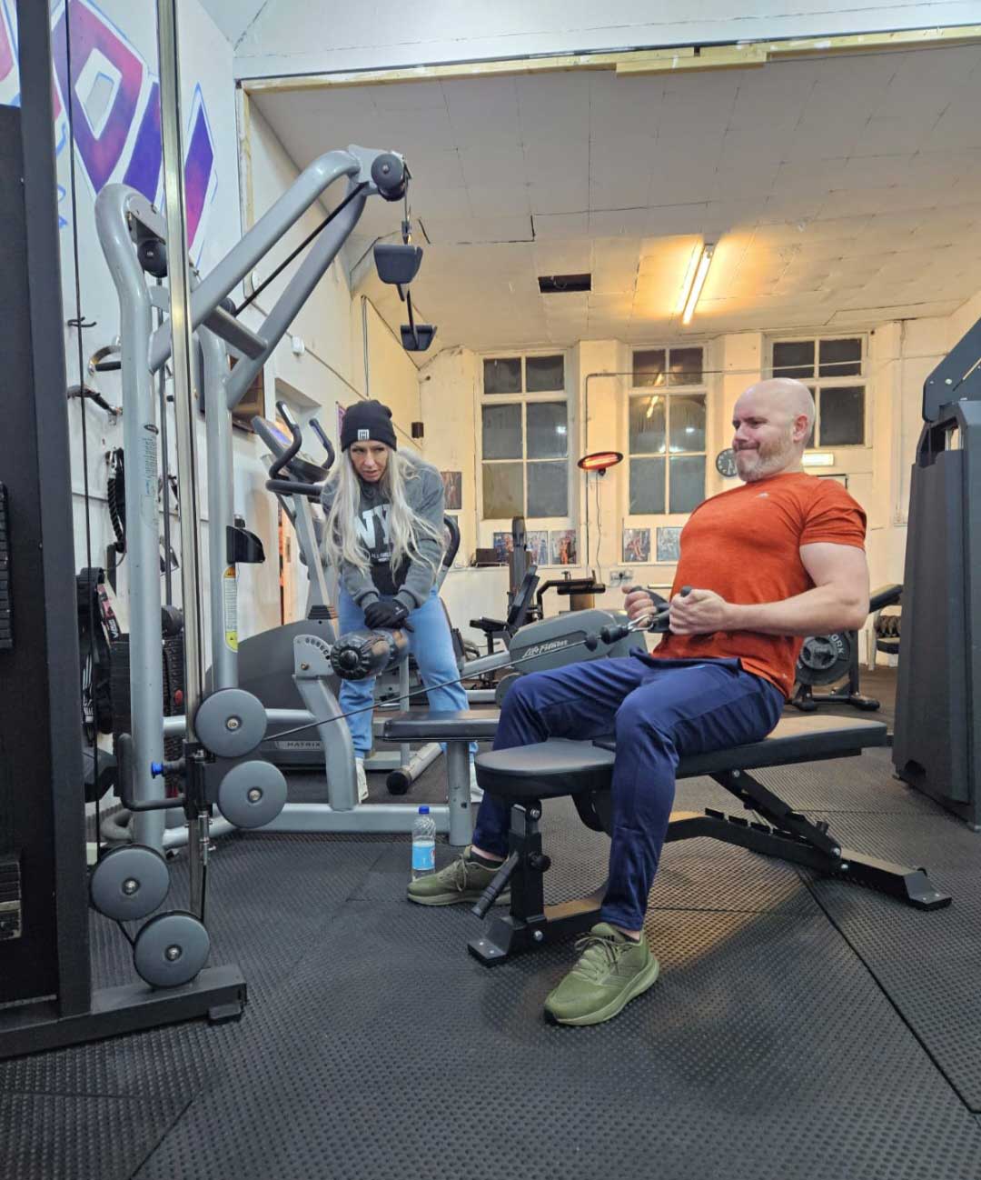 A B-Strong coach guiding a member through a session in the Swinton gym